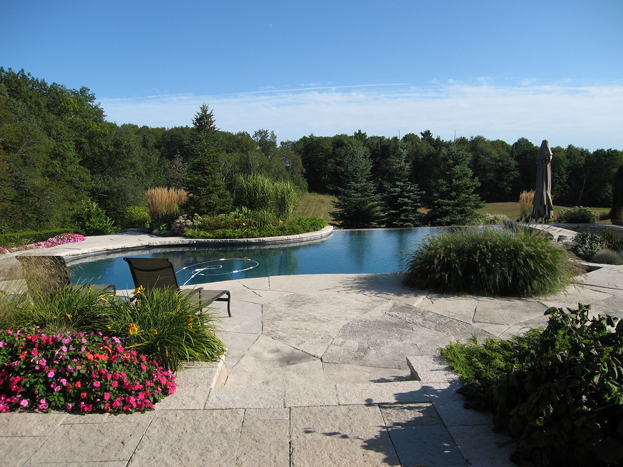 a natural stone pool can enhance the versatility of your backyard landscape